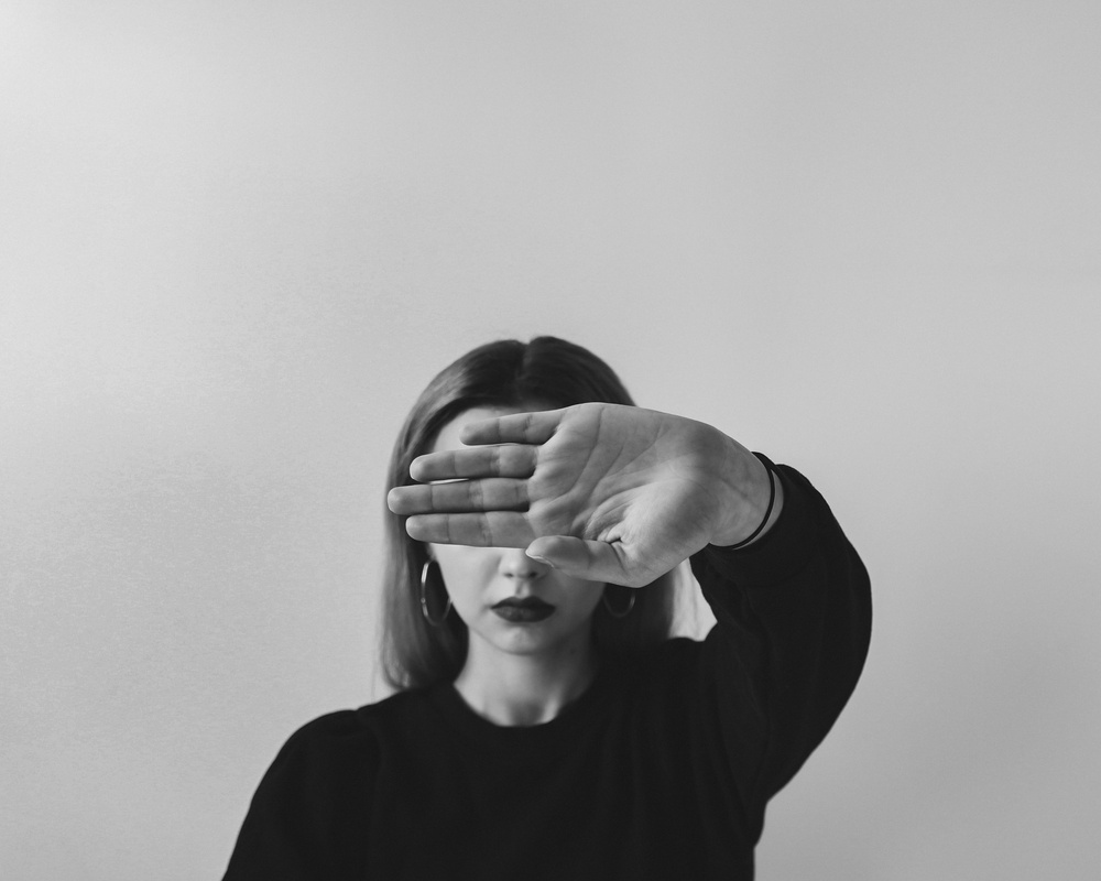 Woman in Black Long Sleeve Shirt Covering Her Face With Her Hands